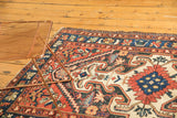 Vintage Baktiari rug's bold rams horn medallion and serrated leaves in navy, red, ivory.