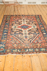 Vintage Persian Baktiari rug end, with light tatter and a colorful floral border.
