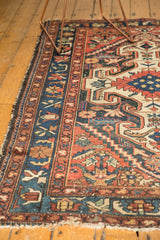 Vintage Baktiari rug detail with cherry red border, navy blue vinery, visible wear, light tatter.
