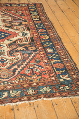 Colorful blossoms and serrated leaves on the navy border of a vintage Baktiari rug.