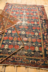 Baktiari rug's lattice of red, navy, ivory germinating plants with even wear.