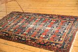 Detail of vintage Baktiari rug corner: lattice floral field, geometric border, tattered fringe.