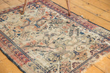 Worn ivory ground of the Antique Shirvan rug, showing oversized medallions and threadbare blue, red patterns.