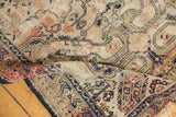 Worn ivory ground of an antique Shirvan rug with deep blue, red geometric and vine motifs.