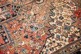 Textured pile of vintage Heriz carpet showing traditional brick red and navy geometric patterns.