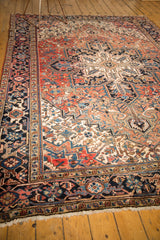 Traditional Heriz carpet's navy and brick red geometric borders with ivory fringe.