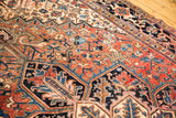 Vintage Heriz carpet showing geometric patterns, robust brick red, navy, and ivory with an evenly worn pile.