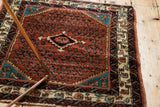 Angled view of a collector's vintage Engelas rug with saturated ruby red and sapphire tones.