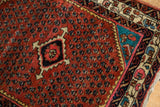 A Collector Persian rug's corner with a sapphire blue spandrel and ruby red boteh field.
