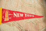 Vintage New York City pennant detail, cream Empire State Building and 'NEW YORK' text on red.