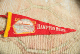 Textured red felt of the vintage Hampton Beach pennant, showing white lettering and graphic.
