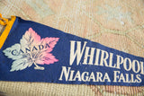 Close view of the pink, white, and blue maple leaf on the vintage Canada pennant.
