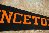 Close-up of distressed orange felt lettering on a black vintage pennant.