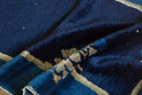 Indigo blue field and beige floral spray pattern of an antique Peking runner, showing white knots.