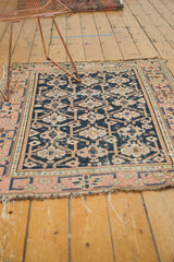 Tattered edge of antique Caucasian rug, revealing dark navy geometric guls and blush border.