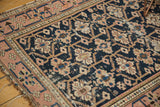 Antique Caucasian rug's dark navy field displays geometric floral guls amidst surface wear.