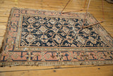 Worn pale dusty blush geometric main border with tattered fringe on the antique Caucasian rug.