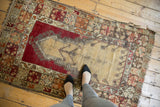 Vintage Melas prayer rug with visible wear, beige field, cherry red, and tangerine orange borders.