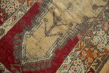 Vintage Melas prayer rug close-up: beige field, cherry red motifs, mostly even wear.
