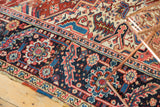 Intricate Heriz main border showing serrated leaves and floral top views in navy and red.