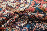 Textured vintage Heriz rug pile with navy, cherry red, and ivory geometric pattern.