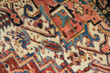 Intricate geometric and curvilinear motifs on vintage Heriz rug in cherry, sky blue, ivory.