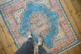 Vintage Kerman rug with distressed sky blue pile and soft pink floral medallion.
