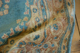 Vintage Kerman rug's sky blue pile, beige pattern, and a localized selvage pull.
