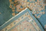 Vintage Kerman rug's hand-knotted foundation, sky blue floral pile, and light blue selvage detail.