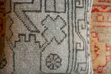 Close-up of hand-knotted Oushak pillow, geometric design in faded gray and mint.