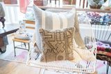 Textured vintage Turkish rug fragment pillow, light gray base with intricate geometric patterns.