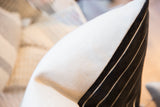 Pillow close-up, showing creamy linen fabric next to black chenille velvet with thin stripes.