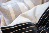 Black chenille velvet fabric with crisp white stripes, contrasting with a light solid textile.