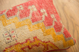 Geometric red and golden yellow pattern on vintage Turkish rug fragment pillow's textural weave.