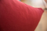 Rich ruby red remnant fabric backing with subtle texture on the lumbar pillow.