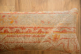Textured vintage Turkish rug fragment lumbar pillow with warm orange and yellow patterns.