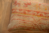 Rustic woven texture of the vintage Turkish rug pillow with orange and yellow patterns.