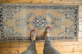 Distressed Oushak runner, pale apricot field, navy floral medallion, mostly even wear.
