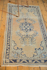 Distressed Oushak runner with pale apricot field, navy and silver floral motifs, mostly even wear.