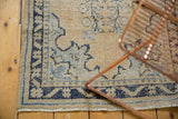 Corner of the distressed Oushak rug runner showing worn texture, dark navy border, and fringe.
