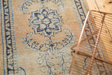 Worn texture detail of vintage distressed Oushak rug showing pale apricot and navy blue.