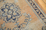Distressed Oushak rug with worn pile texture, pale apricot, navy blue, and silver motifs.
