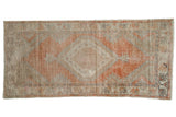 Distressed vintage Oushak runner, faded tangerine and beige, with central medallion and floral palmettes.