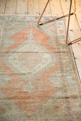 Distressed texture with faded tangerine orange and silver tones on the vintage Oushak runner.