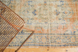 Distressed vintage Oushak rug with faded apricot, ivory, blue floral patterns and border.