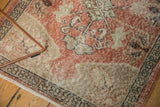 Distressed Oushak rug corner, showing faded dusty rose, beige tones, and even pile wear.