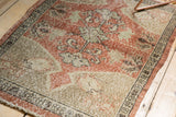 Distressed Oushak rug corner with worn pile, faint foundation, and secured side.
