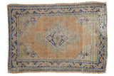 Distressed vintage Oushak square rug with diamond medallion, dusty apricot, ivory, cobalt blue.