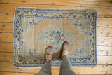 Distressed vintage Oushak rug with pale apricot field and cobalt blue medallion underfoot.