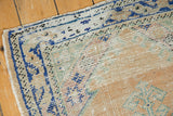 Distressed Oushak rug border with cobalt blue latch motifs, pale apricot, and worn knot heads.